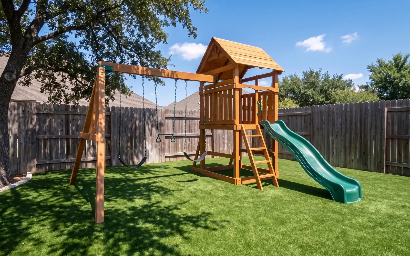 A wooden swing set and slide standing on artificial turf in a backyard
